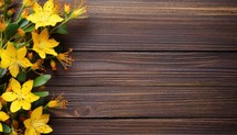 Yellow flowers on brown wooden background. Top view with copy space.