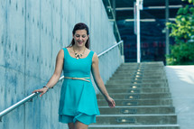 a woman in a blue dress walking down steps 