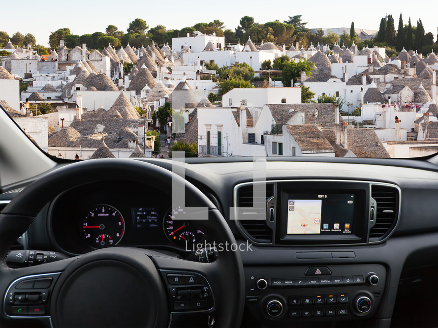 View of a car dashboard with a navigation unit traveling to Alberobello