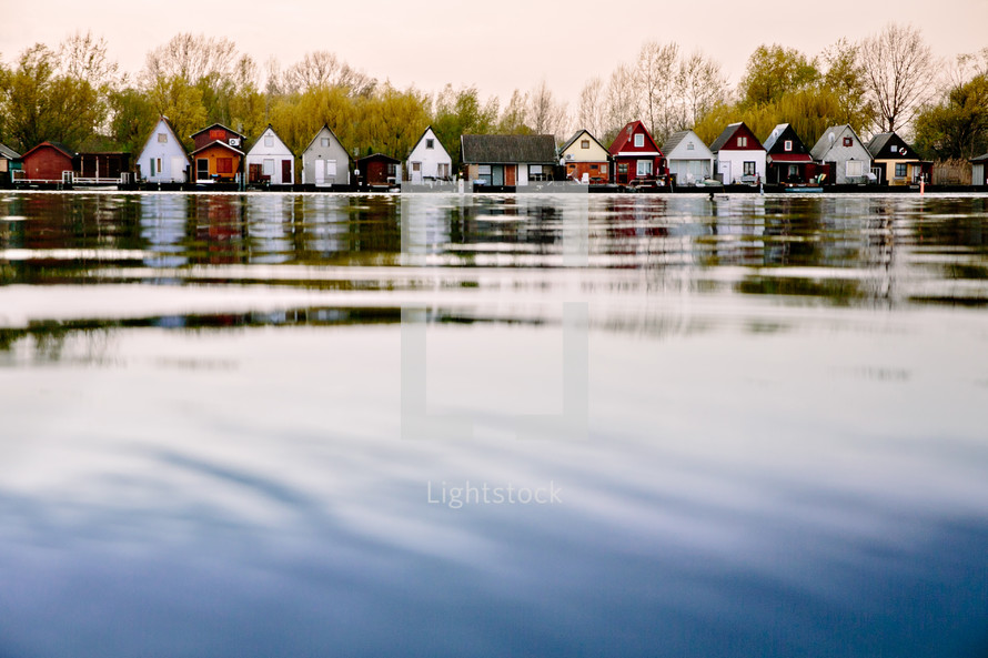 Quaint little houses line a lakeshore.