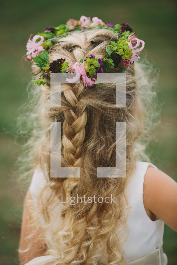 crown of flowers and berries in the hair of a flower girl
