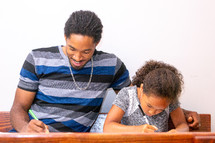 a father coloring with his daughter 