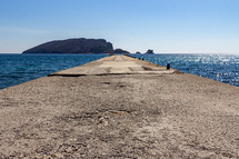 Empty pier on Beach Greco with a view of Saint Nikola Island in the background in Budva, Montenegro