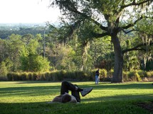 A man relaxes at a green meadow park in Central Florida enjoying the great outdoors and quiet time alone with God.