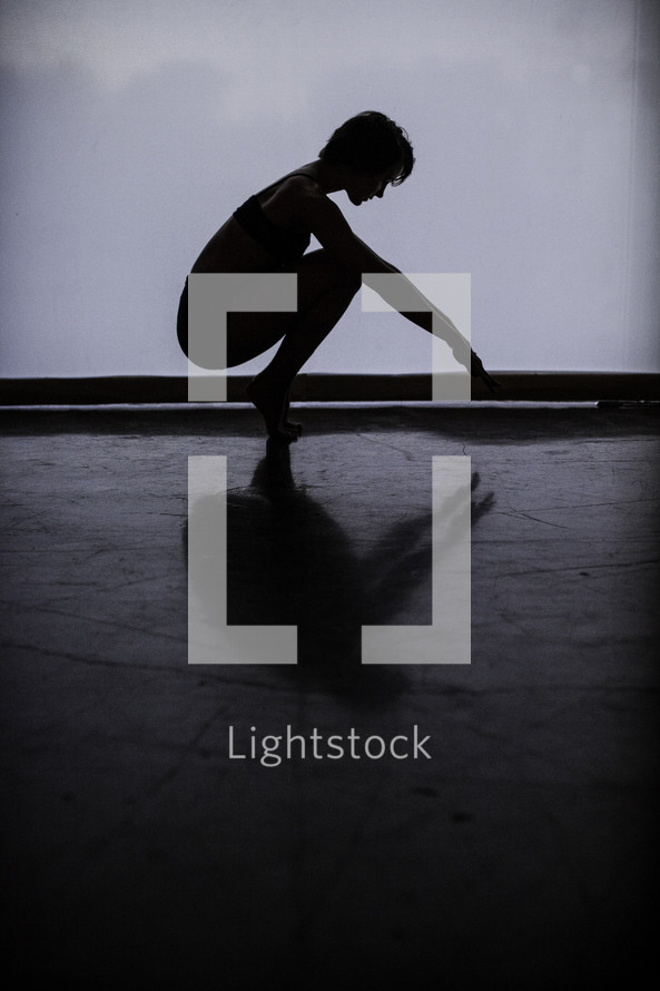 silhouette of a dancer squatting 