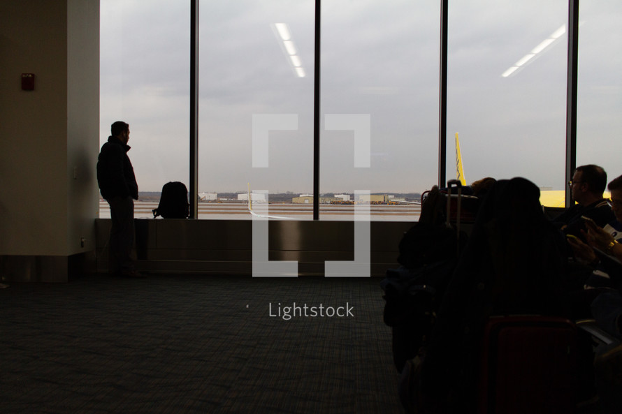 man standing in an airport window 