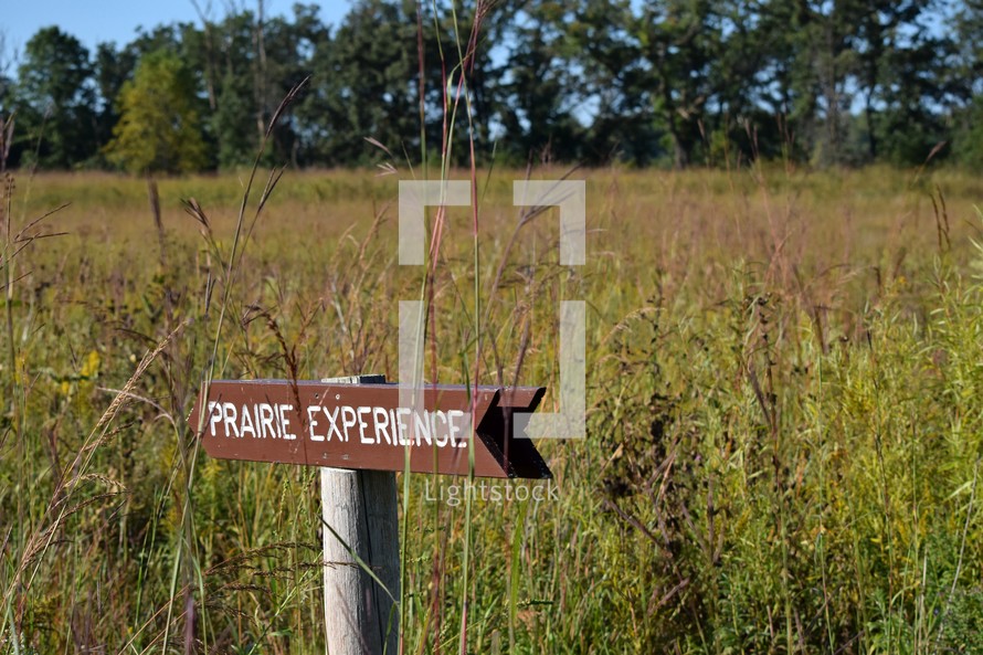 "Prairie Experience" sign in a field