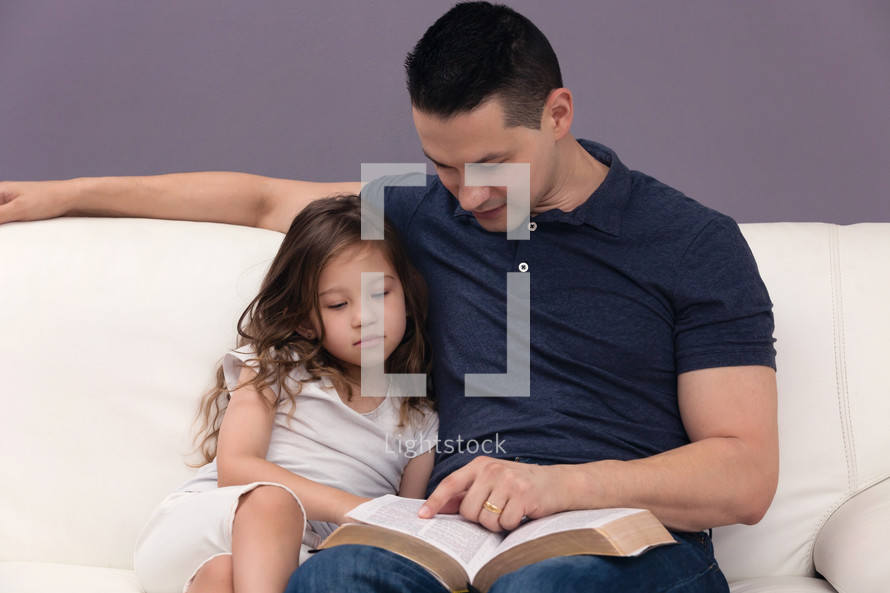 Man Reading Holy Bible to his daughter 