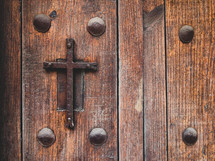 metal cross on a wood church doors 