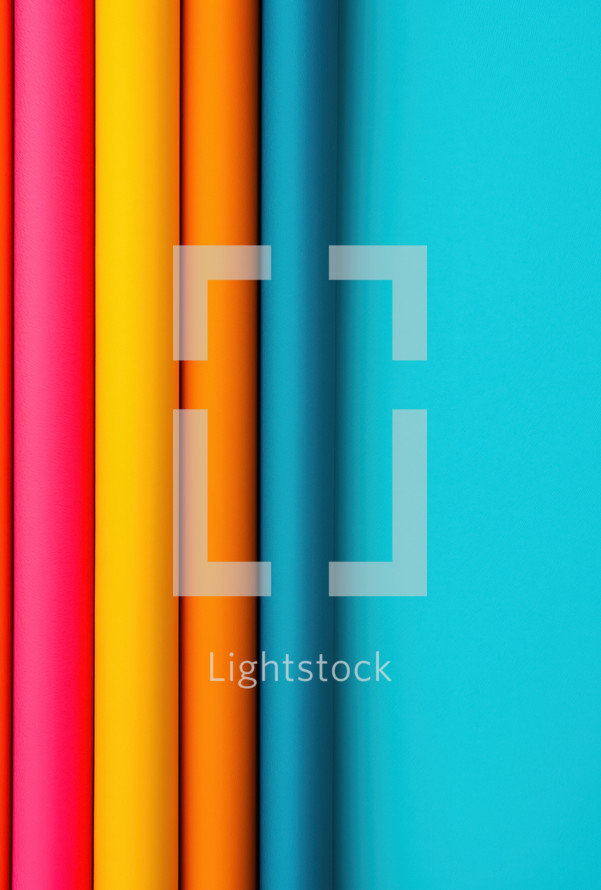 Vibrant, colorful rolls of material aligned vertically against a bright blue background, emphasizing minimalism and modern design.