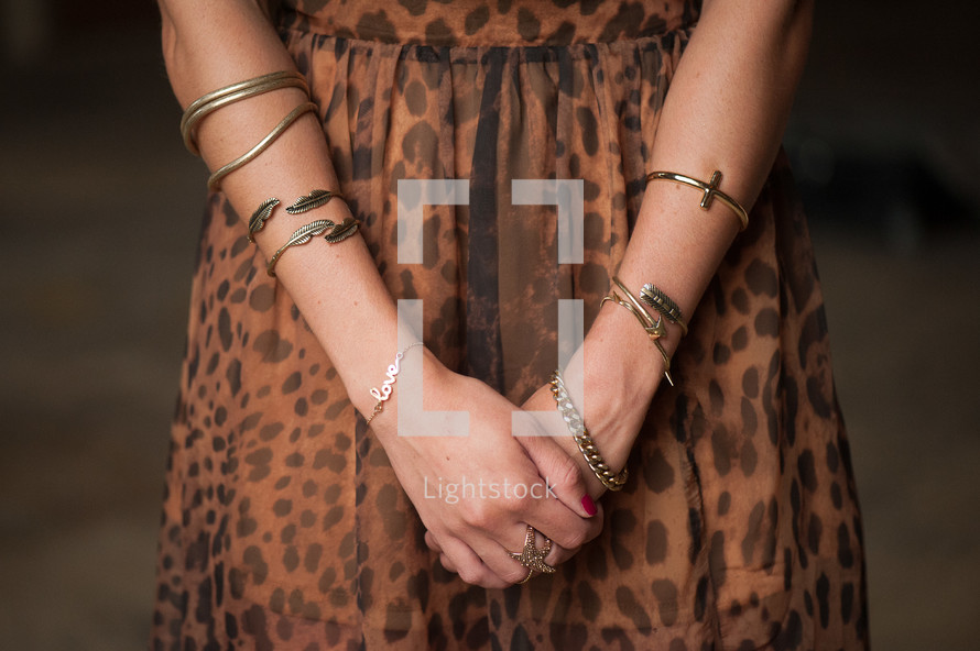 Woman's arms with gold bracelets.