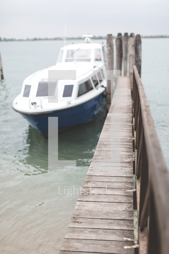 A boat docked at a wooden pier.