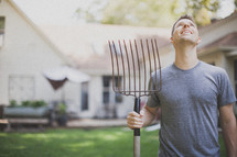 man holding a rake and looking up to God