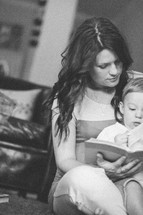 mother reading a Bible with her toddler son