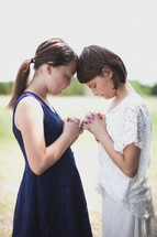 Girls praying outside.