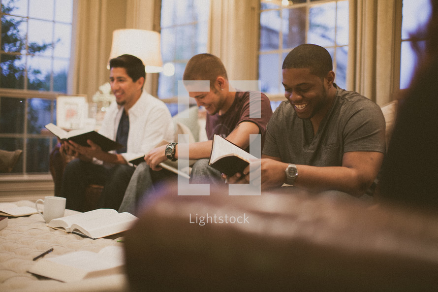 men on the couch reading Bibles at a bible study