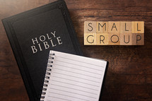 Bible and notebook on a wood background - small group 