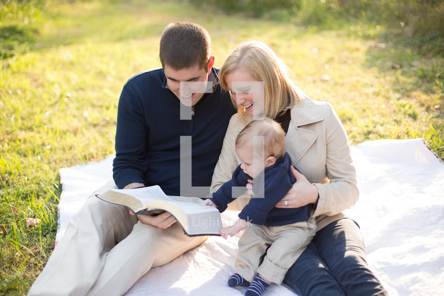 A family reading the bible outside
