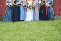 bride and bridesmaids in front of a barn