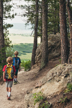 boys hiking on a path in a forest 