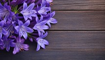 Beautiful purple flowers on wooden background. Top view with copy space