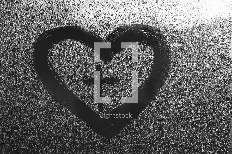 water droplets on glass and heart with cross 