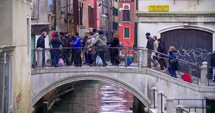 People crossing the bridge over the water canal 