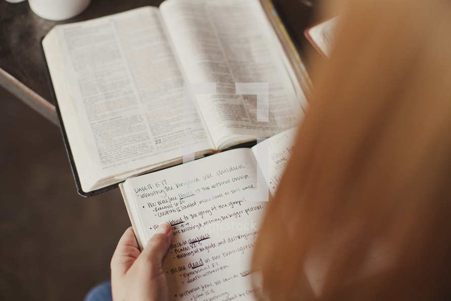 reading a Bible and writing in a journal during a Bible study
