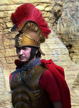 A Roman Soldier dressed in full military gear including helmet, breastplate and cape stands guarding the Tomb of Christ. 