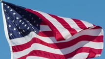 American flag waving against a blue sky 
