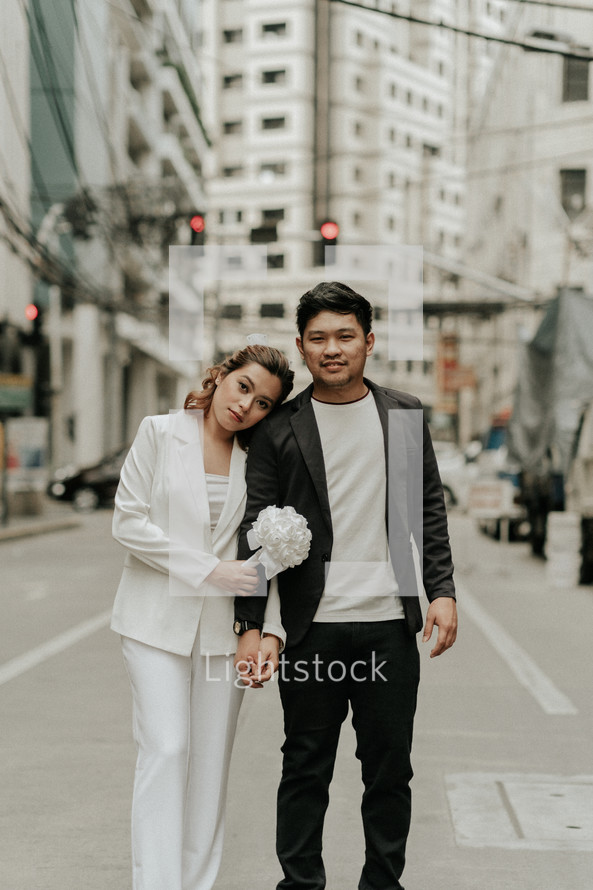 bride and groom walking in a city 