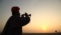 silhouette of a man playing a horn 