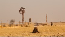 smoke from a fire and windmill in a desert 
