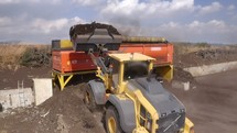 Aerial shot of an Industrial compost production site. Large rotary compost screening machine filtering compost
