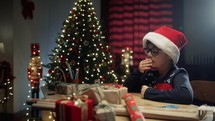 Little boy yawning and falling asleep on his desk in Christmas