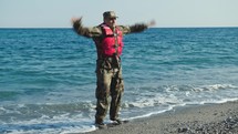 Military man training jumping jack on the shore