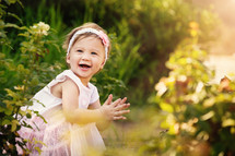 toddler girl outdoors clapping her hands 