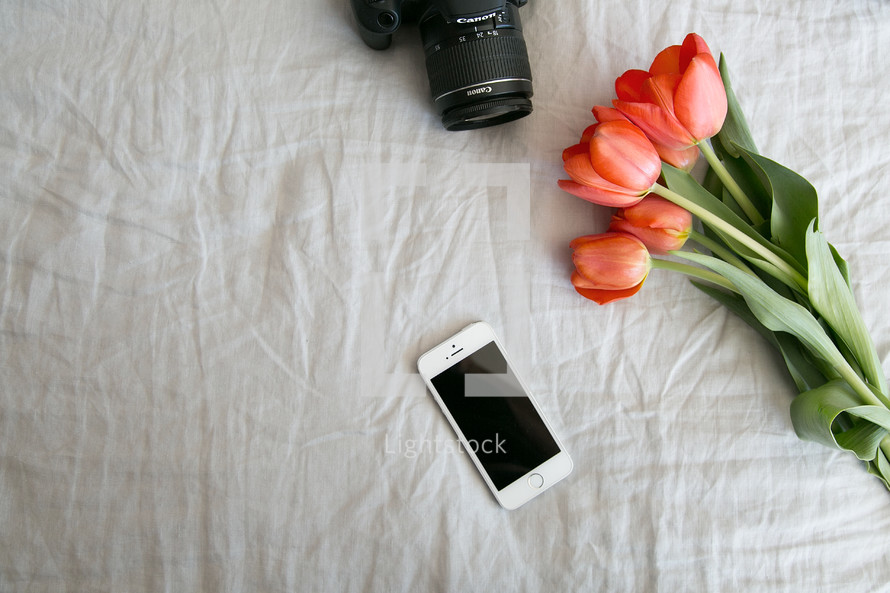 camera, iPhone, tulips on white linen 