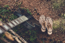 guitar and shoes on the ground 