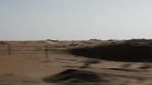 Middle Eastern desert scenery landscape near Duba, United Arab Emirates with sand blowing in the wind in cinematic slow motion.