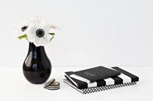 flowers in a black vase and black and white journal 