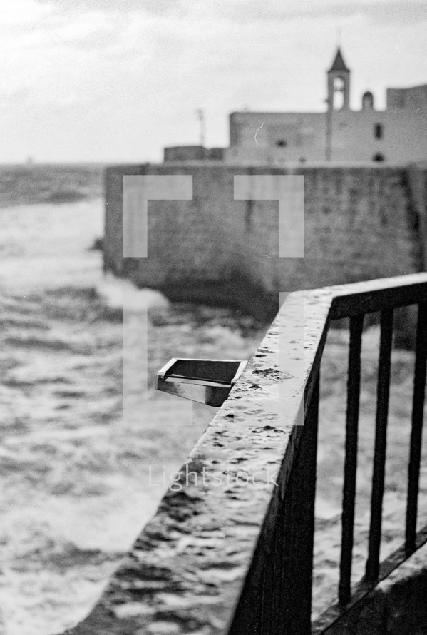 Black and white waves near stone wall in Jaffa, Israel
