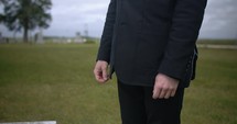 Young man in black suit standing in cinematic slow motion.