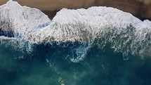 Waves and foam of stormy ocean vertical view