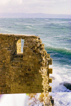 Ocean with waves against stone wall in Jaffa, Israel