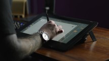 3D animation designer working on an ipad with pencil on workstation
