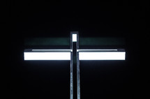 A metal cross against a black background.