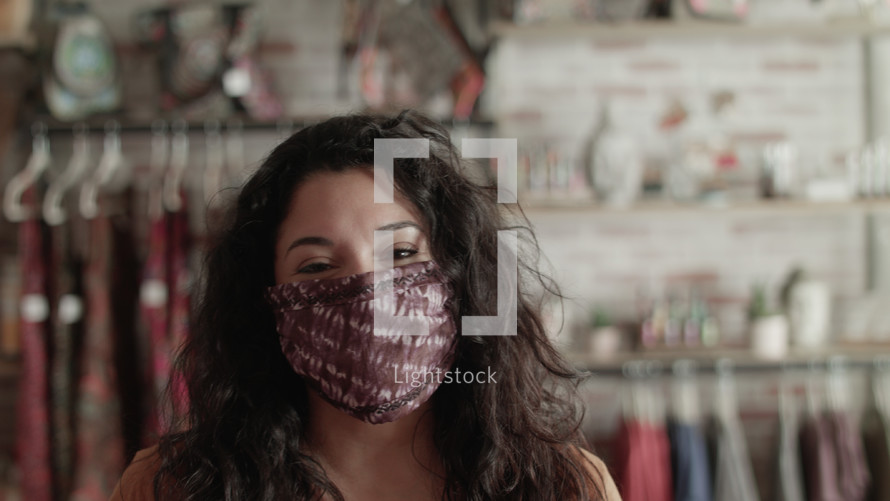 a woman at a boutique wearing a face mask 