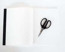 scissors on an open notebook 