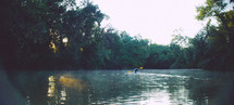 man paddling a kayak on a river 